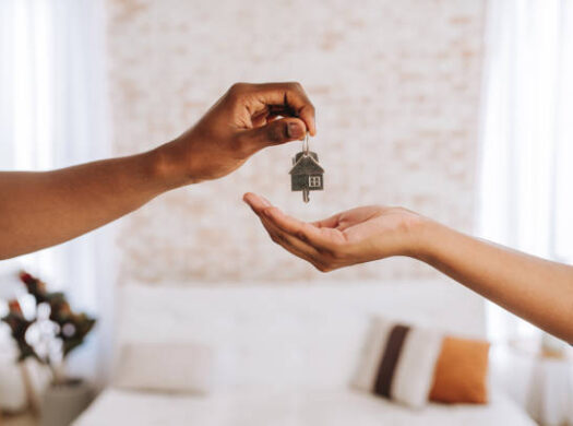 Handing over house keys with a small house keyring at a Savannah closing