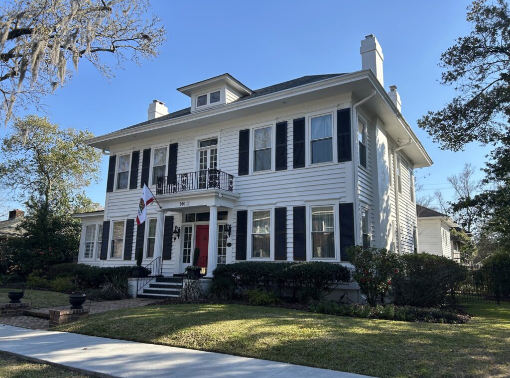 Colonial Revival home with black shutters and red door in Ardsley Park, Savannah GA