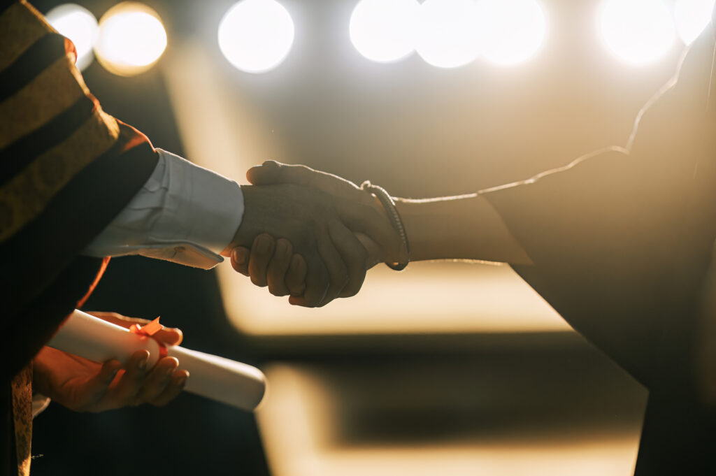 Graduation ceremony diploma handshake