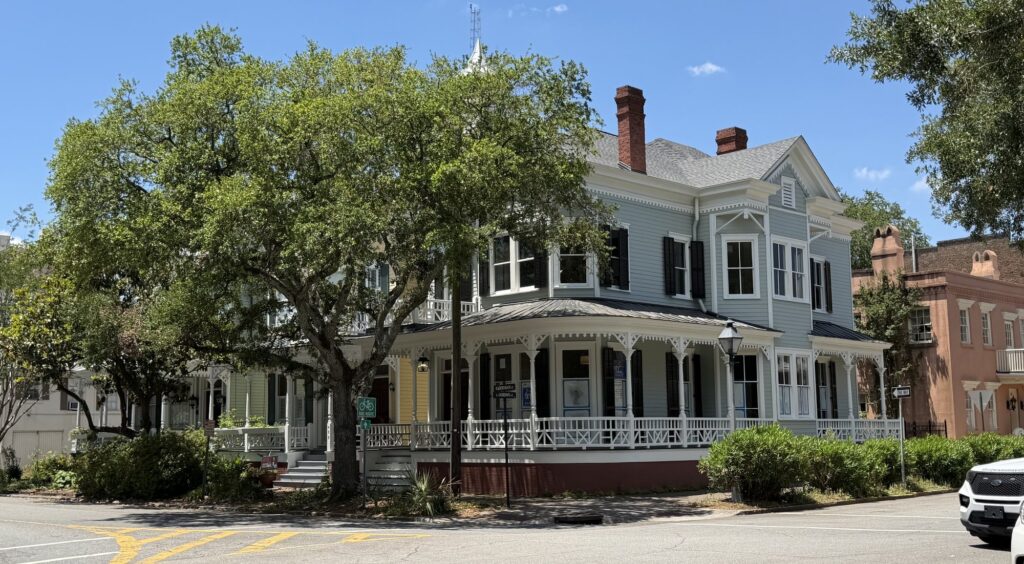 Blue-gray Victorian home with wraparound porch on a corner lot in Savannah Historic District, GA
