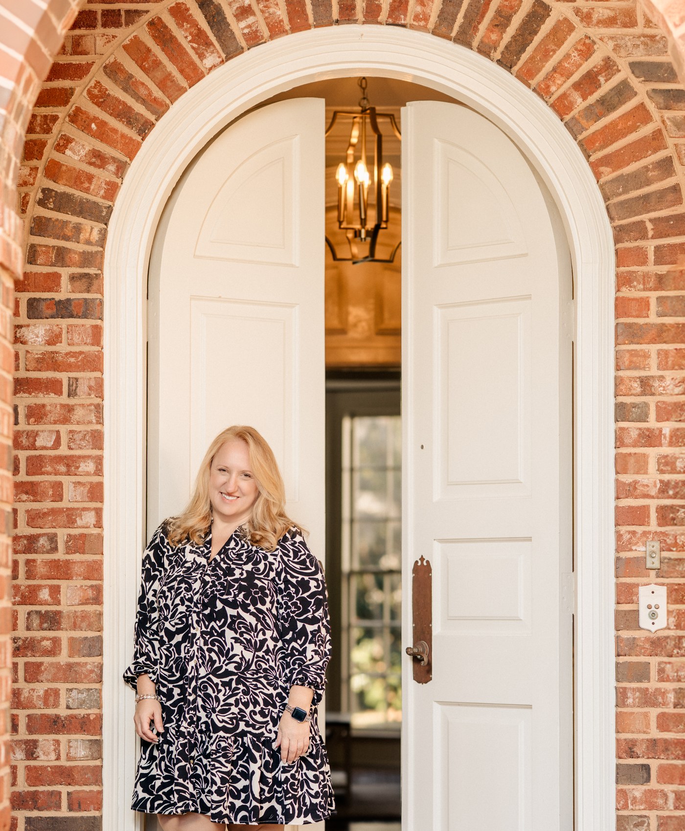 Nikki Gergacs, Savannah Realtor, in an arched brick doorway
